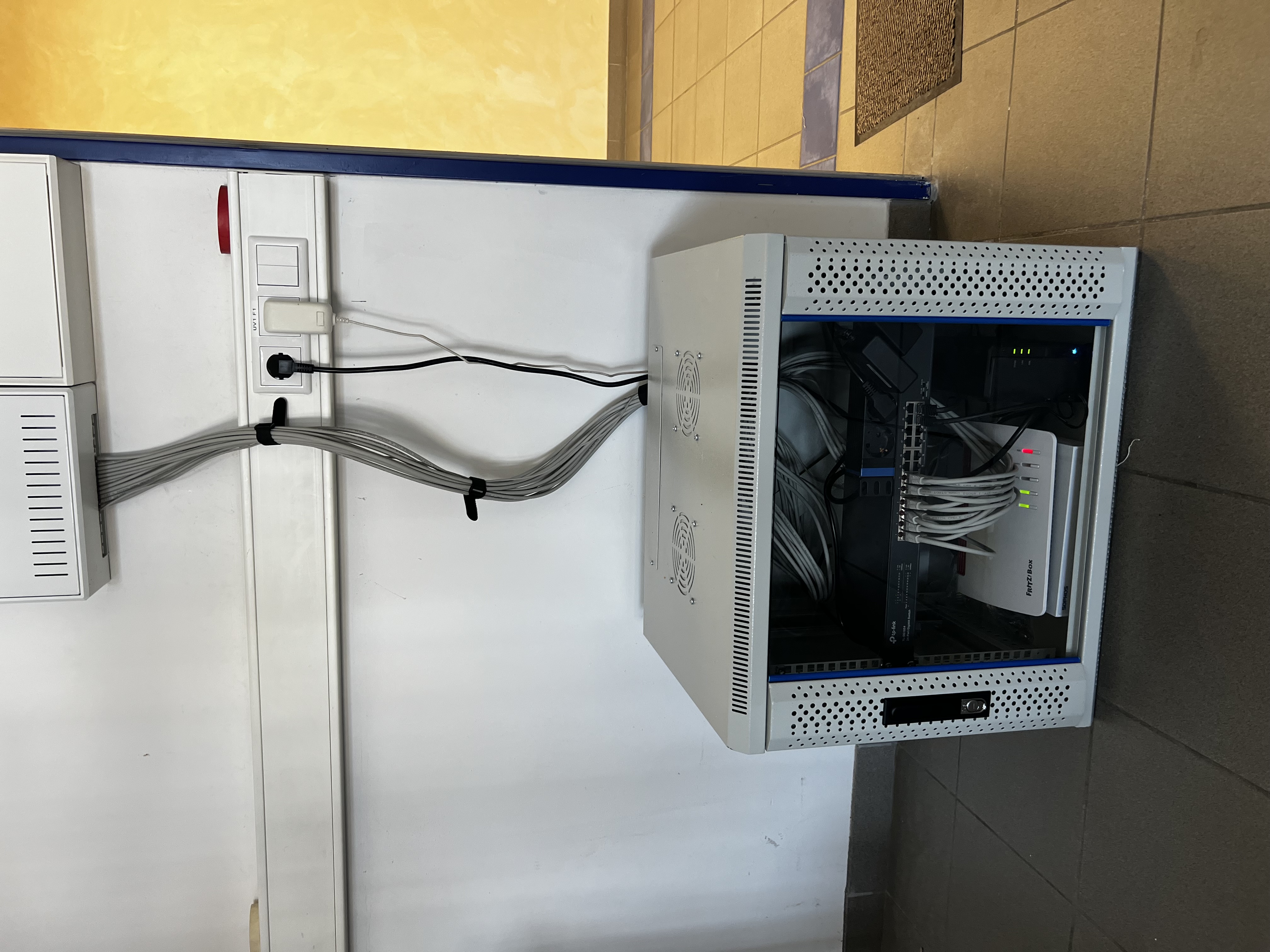 Nachher: aufgeräumter wandmontierter 19-Zoll-Netzwerkschrank mit strukturierter Verkabelung, Managed Switch und FRITZ!Box nach der Modernisierung durch IT-ZU